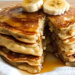 Sourdough Discard Banana Pancakes 8 Golden brown banana pancakes made with sourdough discard, topped with fresh bananas and a drizzle of maple syrup.