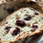 Cranberry Pecan Artisan Sourdough Bread 8 Freshly baked cranberry pecan artisan sourdough bread with a golden crust and studded with visible cranberries and pecans.