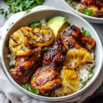 hawaiian bbq chicken recipe 8 Grilled Hawaiian BBQ chicken topped with pineapple and green onions, served on a white plate with a side of rice.