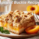Golden apricot buckle slice on white napkin with water glass and natural lighting