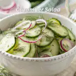 Top-down view of a cucumber salad with red onions and dill in a white bowl
