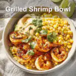 Grilled Shrimp Bowl with Avocado and Corn Salsa on a clean, natural table setup.