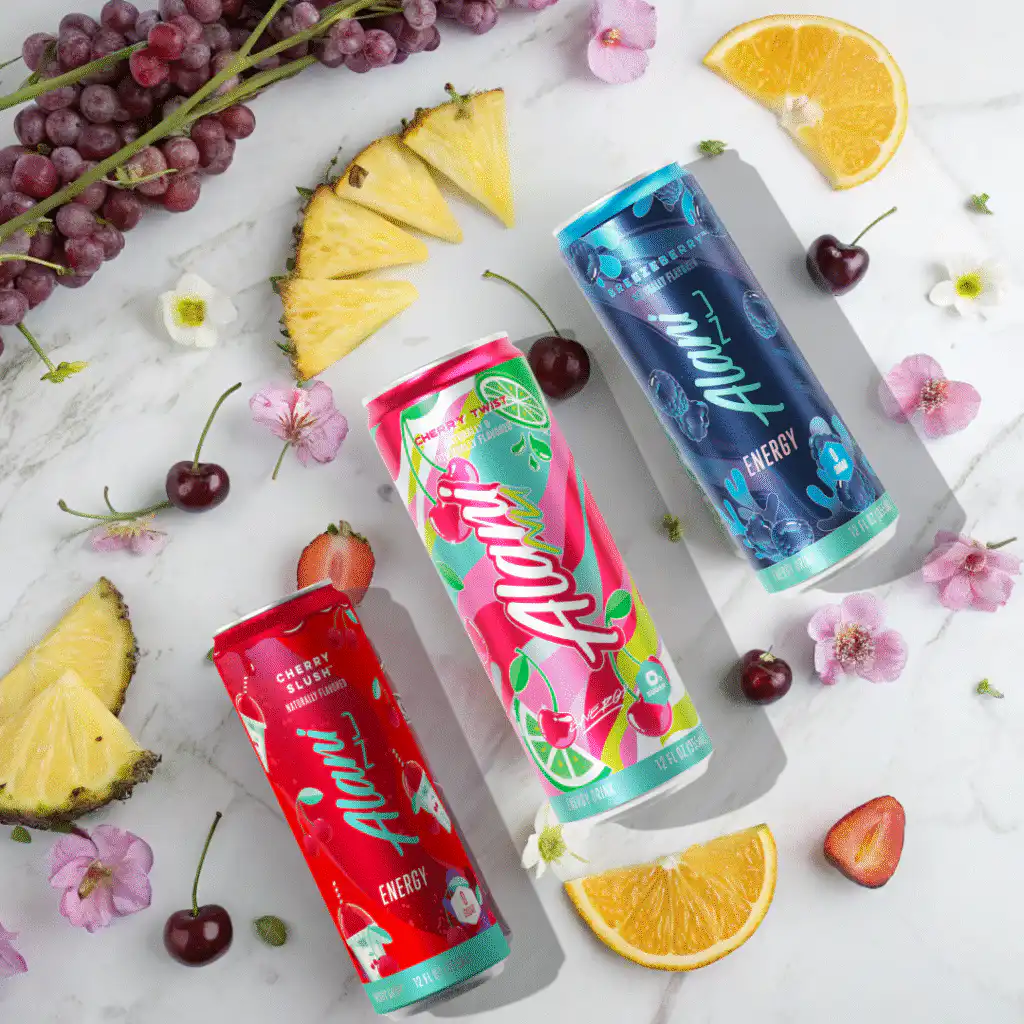 Alani Energy Drink Review: Is It Really Worth the Hype? 2 Five Alani Energy Drink cans with sliced fruits on a marble counter