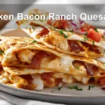 Chicken Bacon Ranch Quesadilla on white napkin with glass of water and sliced view