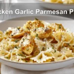 Chicken Garlic Parmesan Pasta plated with farfalle and grated cheese on white napkin beside clear water glass