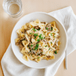 Plated Creamy Parmesan Garlic Beef Bowtie Pasta garnished with parsley and Parmesan cheese - meal ready to serve.