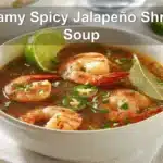 Creamy Spicy Jalapeño Shrimp Soup in a warm bowl garnished with lime and fresh green herbs