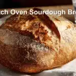 Dutch Oven Sourdough Bread presented on white cloth with clear glass of water beside it