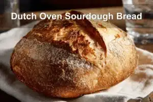 Dutch Oven Sourdough Bread presented on white cloth with clear glass of water beside it