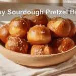 Golden-brown Easy Sourdough Pretzel Bites on white napkin with glass of water beside.