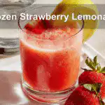 Refreshing frozen strawberry lemonade in a tall glass with garnish on a white napkin.