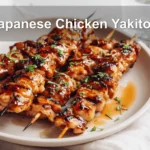 Japanese Chicken Yakitori skewers on a white napkin with rich glaze and natural lighting.