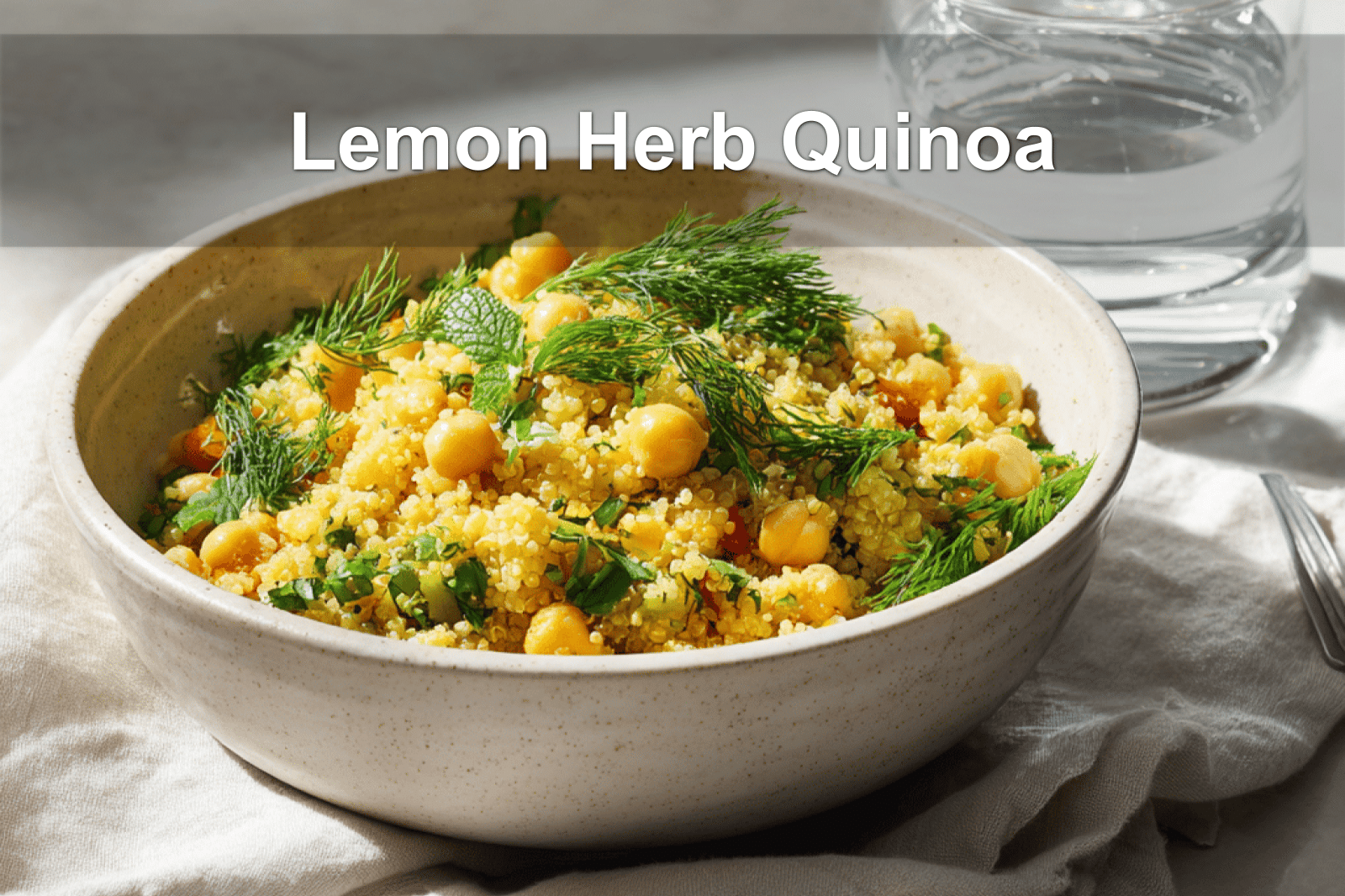 Lemon Herb Quinoa with Chickpeas beautifully presented on a white napkin with a glass of water