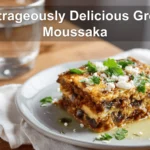 Outrageously Delicious Greek Moussaka with golden topping fresh herbs clean white napkin