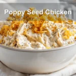 Poppy Seed Chicken casserole served with creamy sauce and crushed crackers on a clean table.