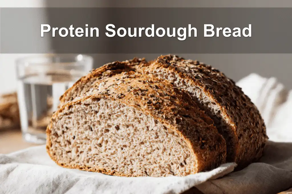 Freshly baked Protein Sourdough Bread with sliced loaves on white napkin and glass of water beside it