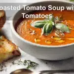 Roasted Tomato Soup with Tomatoes in bowl with grilled cheese basil under warm natural light