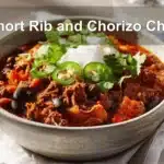 Short Rib and Chorizo Chili served with toppings in a rustic bowl, styled on white napkin.