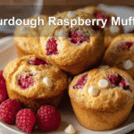 Sourdough Raspberry Muffins served with clear water and warm natural light for fresh gourmet appeal.