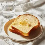 Sourdough Sandwich Bread: Soft, Fluffy, Perfect Loaves 4 Sliced sourdough sandwich bread plated with butter on a white napkin.
