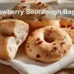 Strawberry Sourdough Bagels on white napkin with water glass beside them