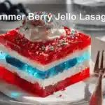 Summer Berry Jello Lasagna dessert with colorful layers on a white napkin and glass of water.