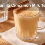 Vanilla Cinnamon Milk Tea served in a glass mug on a white napkin under natural light.