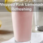 Whipped Pink Lemonade Refreshing Recipe in a clear glass, lightly styled with a raspberry garnish.