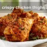 Crispy chicken thighs plated on white cloth with clear glass of water warm natural light