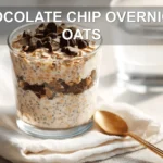 CHOCOLATE CHIP OVERNIGHT OATS creamy jar topped with vegan chips in warm natural light