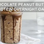 CHOCOLATE PEANUT BUTTER PROTEIN OVERNIGHT OATS in jar with peanut butter drizzle and chocolate chips