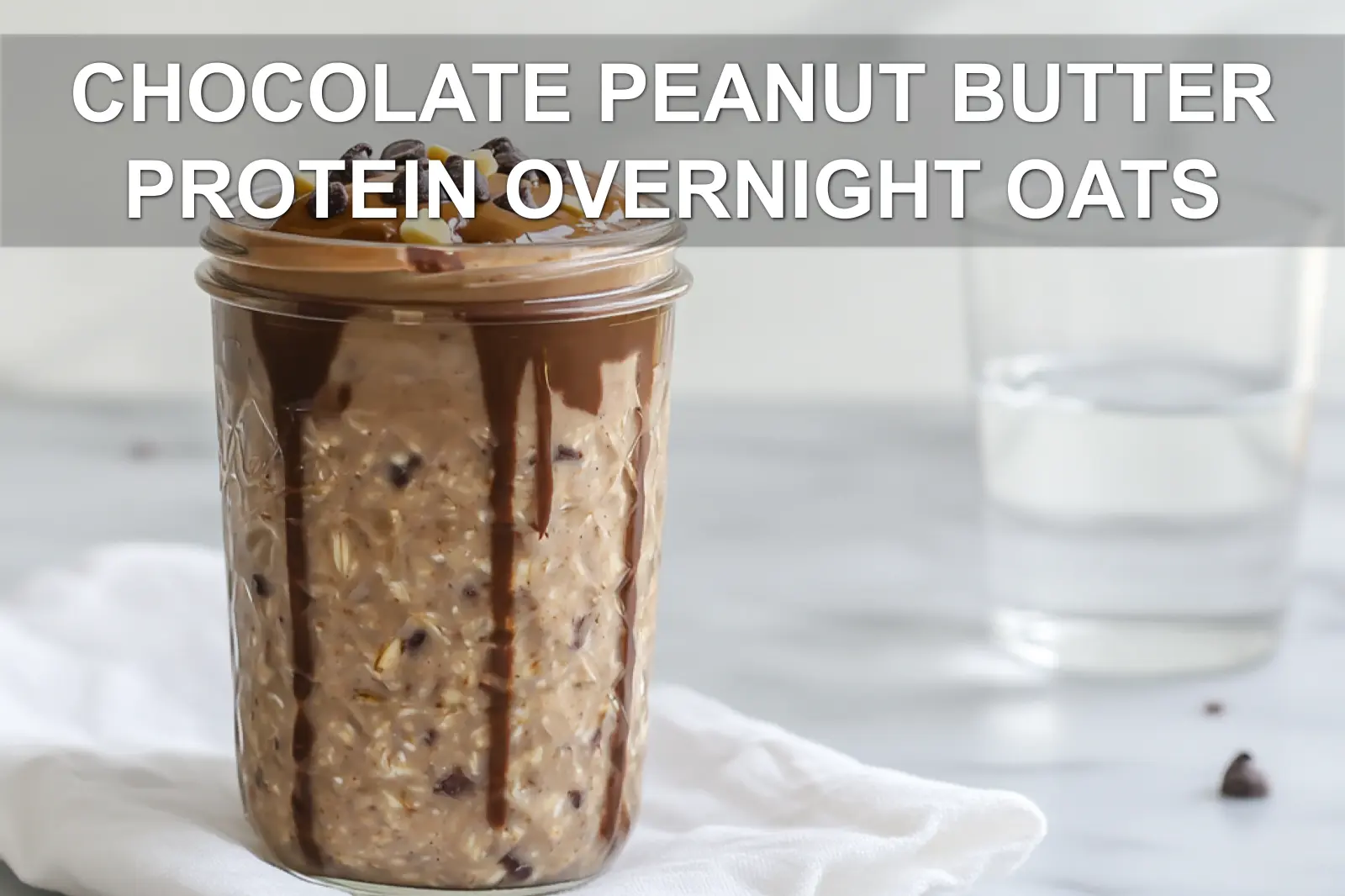 CHOCOLATE PEANUT BUTTER PROTEIN OVERNIGHT OATS in jar with peanut butter drizzle and chocolate chips