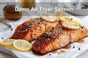 Damn Air Fryer Salmon plated with lemon slices honey soy glaze olive oil bottle beside glass