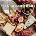 Fall Charcuterie Board with brie cheddar gouda blue cheese prosciutto salami fruit and nuts