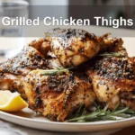 Grilled Chicken Thighs on white napkin with clear water glass warm natural light
