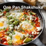 One Pan Shakshuka overhead skillet vibrant eggs tomato sauce herbs melted cheeses and bread