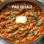 PAV BHAJI hero bowl with buttered pav herbs lime wedge and glass of water
