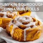 PUMPKIN SOURDOUGH CINNAMON ROLLS warm three quarter hero shot with glass of water