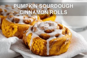 Pumpkin Sourdough Cinnamon Rolls: Easy and Delicious PUMPKIN SOURDOUGH CINNAMON ROLLS warm three quarter hero shot with glass of water