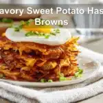 Savory Sweet Potato Hash Browns on white napkin with glass of water and golden crust