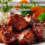 Slow Cooker Sticky Honey Chicken plated with white rice broccoli carrots on a white napkin beside water