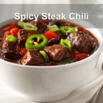Spicy Steak Chili in bowl on white napkin warm inviting natural light glass of water