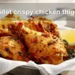 skillet crispy chicken thighs golden crisp skin lemon thyme on white napkin
