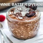 BROWNIE BATTER OVERNIGHT OATS creamy chocolate oats topped with berries dates dark chocolate and coconut flakes