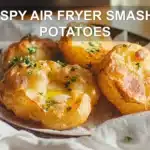 CRISPY AIR FRYER SMASHED POTATOES on white napkin with herbs and golden crisp edges