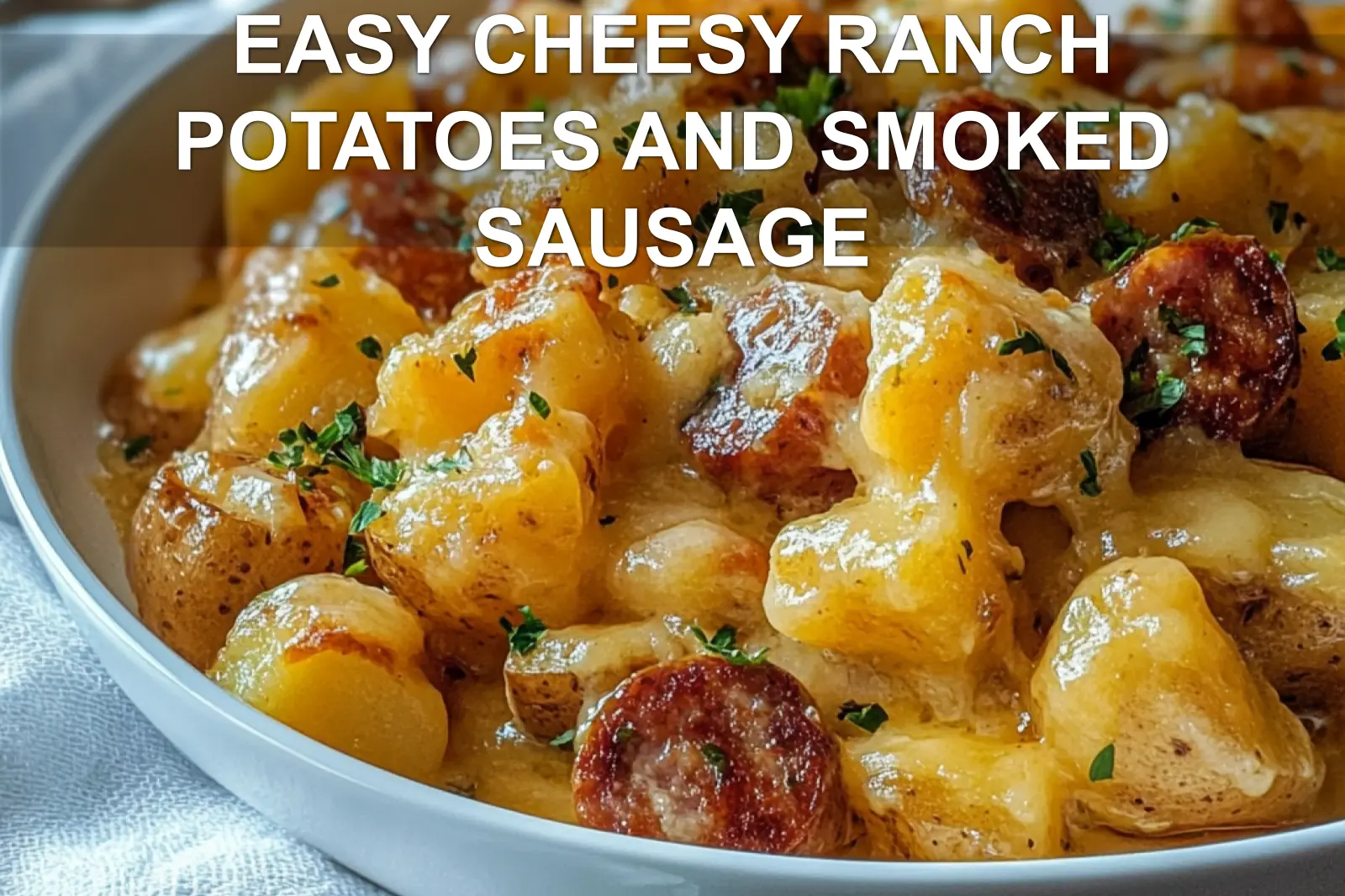 EASY CHEESY RANCH POTATOES AND SMOKED SAUSAGE in warm close up with herbs and melted cheese