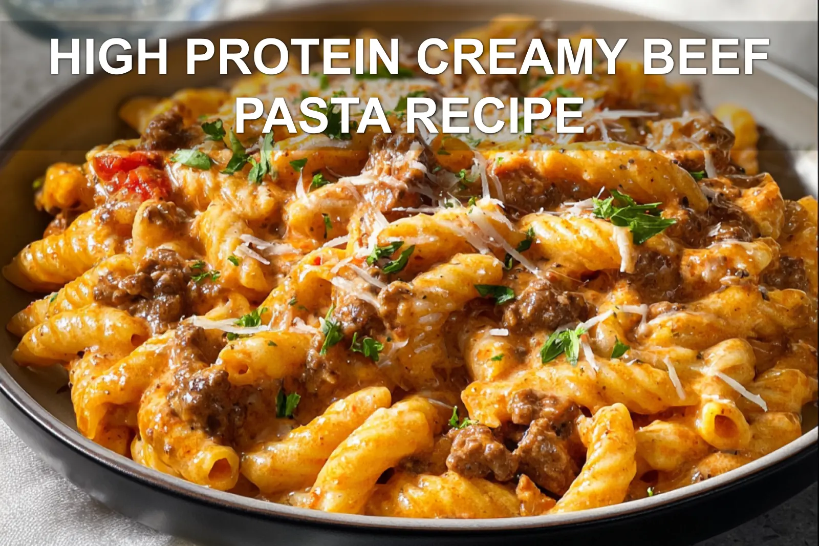 HIGH PROTEIN CREAMY BEEF PASTA RECIPE plated penne with ground beef creamy yogurt sauce fresh herbs