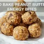 NO BAKE PEANUT BUTTER ENERGY BITES on white napkin with clear glass of water warm light