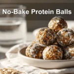 NO BAKE PROTEIN BALLS on white cloth with glass of water warm natural light