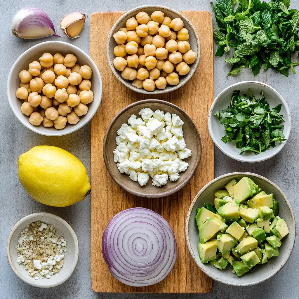 Vibrant Chickpea Feta Avocado Salad in a white bowl, garnished with fresh herbs.